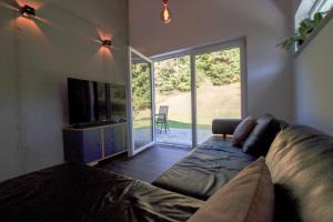 a living room with a couch and a television at Albsommer - Fehlatal Ferienhäuser in Burladingen