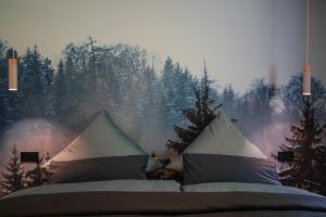 ein Schlafzimmer mit einem Bett und Bäumen im Hintergrund in der Unterkunft Albsommer - Fehlatal Ferienhäuser in Burladingen