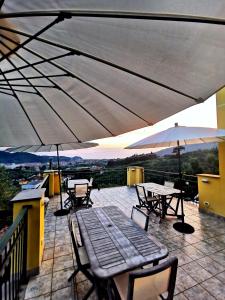 un patio con tavoli e ombrelloni su un balcone di Le Fiabe a Sestri Levante