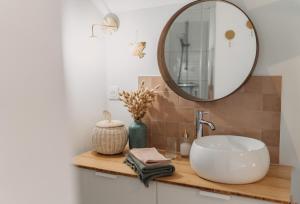 a bathroom with a sink and a mirror on a counter at Grange Petite Brise bord de mer in Luc-sur-Mer