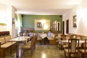 a restaurant with wooden tables and chairs and green walls at Land-gut-Hotel Schenkenberger Hof in Delitzsch