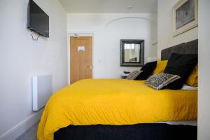 a bedroom with a yellow bed with a yellow blanket at The Sandbeck, Ruswarp in Whitby
