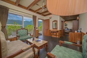 a living room with a couch and a table at Jungle Lodge Resort in Kasauli