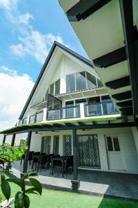 a house with a balcony with tables and chairs at Jacobs Hill Tagaytay in Tagaytay