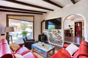 een woonkamer met een rode bank en een tafel bij Villa La Playita in Badia Gran