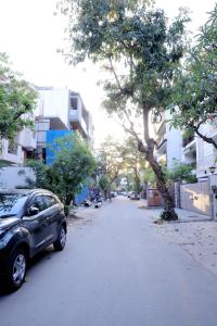 a car parked on a street next to a tree at Divine India Service Apartment 4Bhk D-163 Saket in New Delhi
