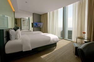 a hotel room with a large bed and large windows at Amman Rotana in Amman