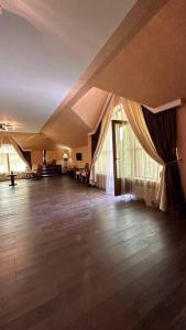 an empty room with curtains and a wooden floor at Mardakan Villa in Mardakan