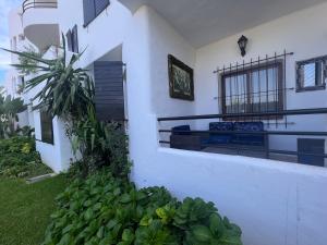 a white house with a balcony and plants at SUPERBE appart 2 ch au résidence balnéaire colina smir in M'diq