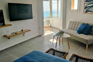 a living room with a couch and a tv at Loft La Cala de Mijas beach estudio mirando al mar in La Cala de Mijas