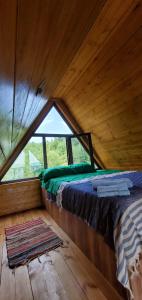 Ce lit se trouve dans une chambre en bois dotée d'une fenêtre. dans l'établissement Seva Villa in Racha, à Oni