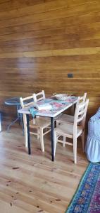 una mesa y sillas en una habitación con una pared de madera en Seva Villa in Racha, en Oni