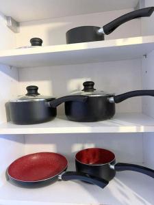 two pots and pans on shelves in a kitchen at 2-bedroom Flat in Sydenham in Forest Hill