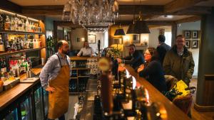 a group of people standing at a bar at The Lion at Malpas in Malpas