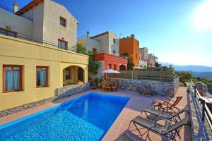 a house with a swimming pool next to a building at Villa Aphrodite by PosarelliVillas in Plaka
