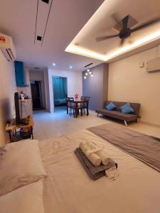 a room with a bed and a living room with a couch at Rest And Go Homestay in Shah Alam