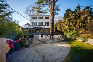 a house with chairs and tables in a yard at Hotel Groenendaal in Hoeilaart