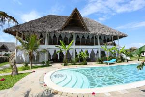 a villa with a swimming pool in front of a resort at Rafiki Jua Resort in Watamu