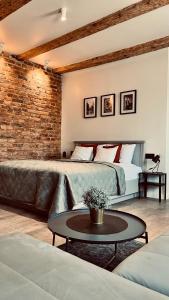 een slaapkamer met een groot bed en een bakstenen muur bij Apartamenty Katowicka 38 in Świętochłowice