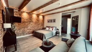 a bedroom with a bed and a brick wall at Apartamenty Katowicka 38 in Świętochłowice