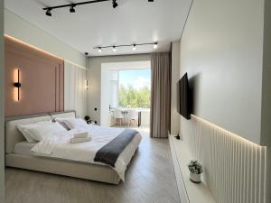 sypialnia z dużym łóżkiem i telewizorem w obiekcie LUX Апартаменты SMART #7 w mieście Pawłodar