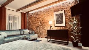 ein Wohnzimmer mit einer Backsteinwand und einer Couch in der Unterkunft Apartamenty Katowicka 38 in Świętochłowice