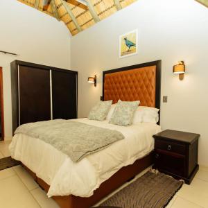 a bedroom with a large bed with a wooden headboard at Kruger Park Lodge Unit 531 - PMP in Hazyview