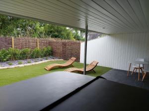 a covered patio with two chairs and a table at Hazel in Bovey Tracey