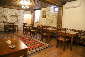 a restaurant with wooden tables and chairs and a rug at Koroni Boutique Hotel in Berat