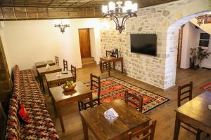 a restaurant with wooden tables and chairs and a stone wall at Koroni Boutique Hotel in Berat