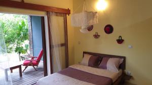 Schlafzimmer mit einem Bett und einer Tür zu einer Terrasse in der Unterkunft Les Citronniers in Sainte Marie