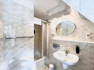 a bathroom with a sink and a shower and a mirror at Groegers Ferienzimmer in Hohwacht