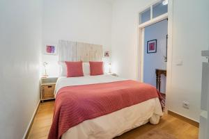 een slaapkamer met een groot bed en een rode deken bij Casa Doce in Silves