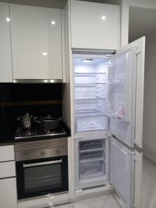 a kitchen with an empty refrigerator and a stove at Edifício 2PALMA in Praia