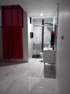 a bathroom with a red shower curtain and a sink at Edifício 2PALMA in Praia