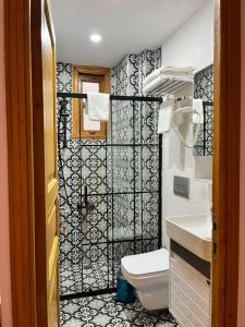baño con aseo y azulejos blancos y negros en DIMORA HOTEL, en Estambul