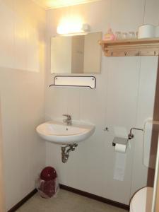 een badkamer met een witte wastafel en een spiegel bij Hotel Am Kleinbahnhof in Emden