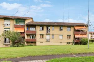 un edificio con un campo de césped delante de él en Zurich Urban Charm: Your comfy stay close to the City en Zúrich