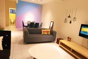 een woonkamer met een bank en een tafel bij 1399 Kulai 12pax 5BR double StoryHouse Near JPO, Airport, AEON in Kulai
