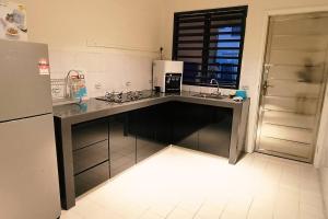 a kitchen with a counter with a sink and a refrigerator at 1399 Kulai 12pax 5BR double StoryHouse Near JPO, Airport, AEON in Kulai