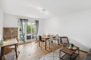 een woonkamer met een tafel en stoelen bij Zurich Urban Charm: Your comfy stay close to the City in Zürich