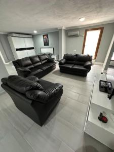 uma sala de estar com sofás de couro preto em Nice Apartment em Marmaris