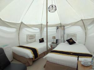 a bedroom with two beds in a white tent at Chevilly Resort & Camp in Bogor +256 photos
