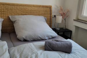 - un lit avec des draps blancs et un oreiller dans l'établissement Berg Messe EG, 2,5 Zimmer, Homeoffice, W-Lan, 
