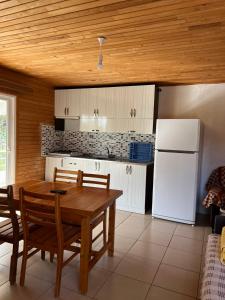 a kitchen with a table and a white refrigerator at Adrasan Parlak Apart in Adrasan