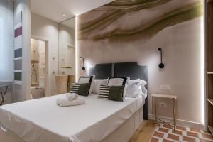 1 dormitorio con 1 cama blanca grande y una pintura en la pared en Estudio vanguardista- 1B- Chamberí, en Madrid