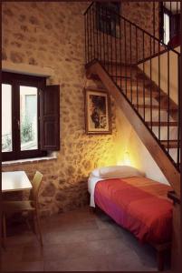 a bedroom with a staircase and a bed and a table at Le Pagliare Del Gran Sasso in Assergi