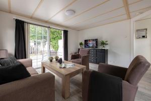 a living room with two couches and a coffee table at 16, Geniet van de rust, natuur & gratis parkeren! in Oisterwijk