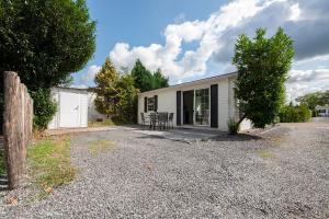 a white house with a patio and a driveway at 16, Geniet van de rust, natuur & gratis parkeren! in Oisterwijk