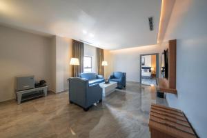 艾卜哈的住宿－فندق بيرلي ابها，客厅配有蓝色椅子和电视